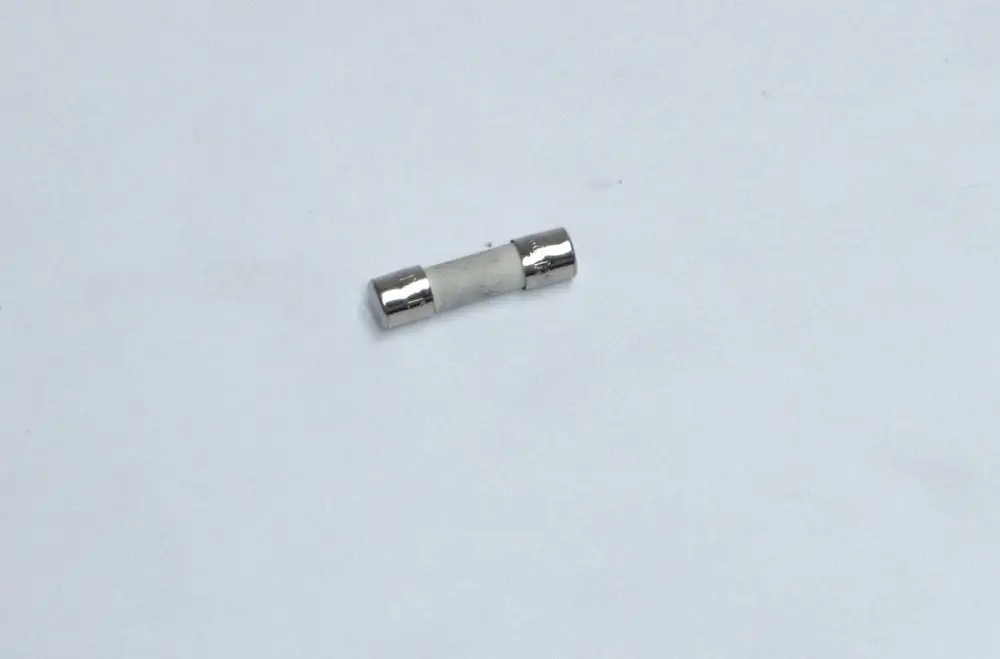 Daikin-Sicherung in zylindrischer Form mit metallischen Enden und einem weißen Mittelteil, auf hellem Hintergrund.